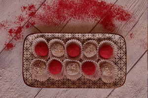 a plateful of cranberry-coconut energy balls on a wooden table