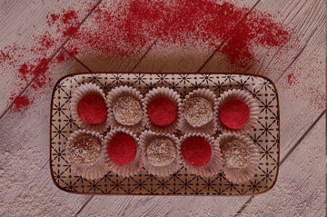 a plateful of cranberry-coconut energy balls on a wooden table