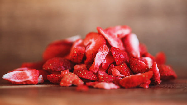 dried berries collection image with freeze-dried strawberry slices piled up on a wooden table